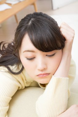 Evde sıkılmış Asyalı bir kadının portresi.