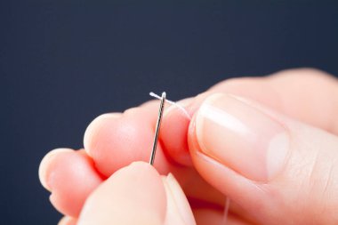 Kadın eli iplikli iğne.