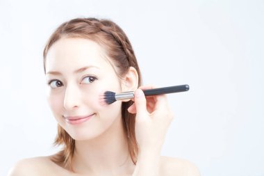 Makyaj fırçası olan kadın