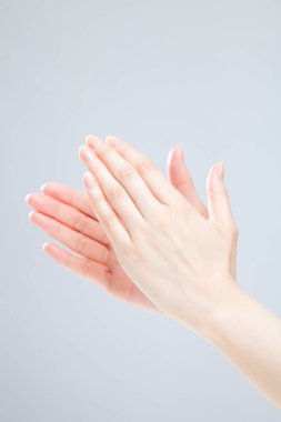 Beyaz arka planda el hareketi yapan kadınların yakın çekimi. 