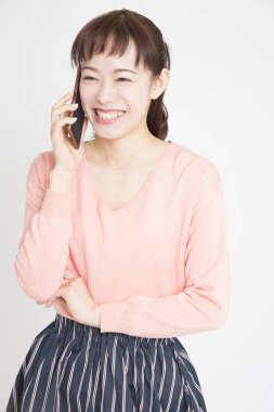 Beyaz arka planda cep telefonu kullanan Asyalı kadın 