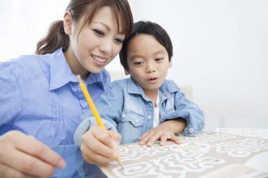 Asyalı anne ve oğul ödev yapıyor.