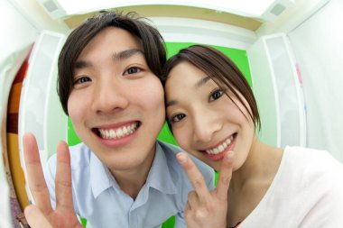 Fotoğraf kabininde poz veren güzel Japon çift.