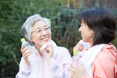 Antrenmandan sonra su içen Asyalı kadınlar