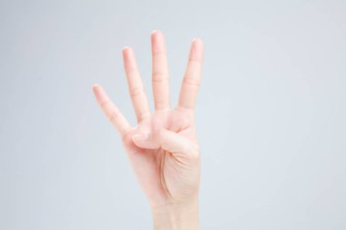 Beyaz arka planda el hareketi yapan kadınların yakın çekimi. 