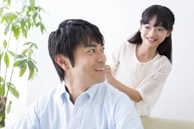 Şirin Asyalı kız babasına masaj yapıyor. evde aile