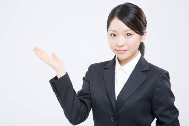 Takım elbiseli bir iş kadını bir şey gösteriyor. 