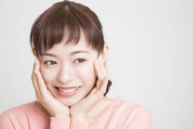 Beyaz arka plan üzerinde gülümseyen genç Asyalı kadın 