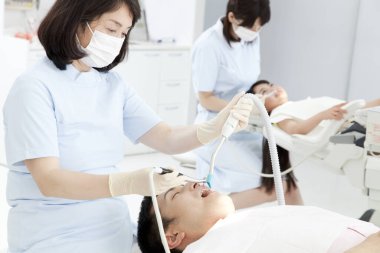 Asyalı dişçi ve erkek hasta