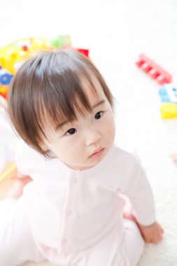 Asyalı bebek oyuncaklarla oynuyor