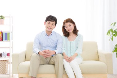 Çift evdeki kanepede oturuyor.