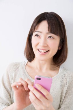 Evde cep telefonu kullanan bir kadın