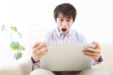 Dizüstü bilgisayarı olan genç bir adam.