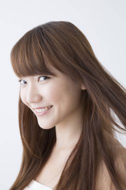 gülümseyerek ve kameraya arayan genç bir kadın