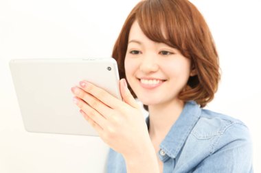 Dijital tablet kullanan gülümseyen Asyalı kadın