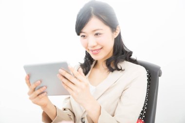 Genç Asyalı kadın evde tablet bilgisayar kullanıyor.