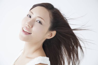 Genç Asyalı kadın kameraya bakıyor, stüdyo çekimi. 