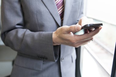 Ofiste akıllı telefon kullanan genç adam