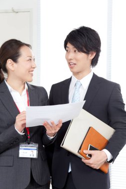 Gülümseyen ofis çalışanları iş belgelerini tartışıyorlar. Takım çalışması konsepti