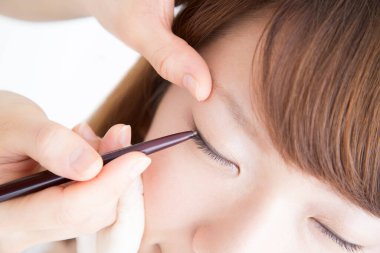 Güzellik salonunda makyaj yapan Asyalı güzel bir kadının yakın çekimi. 