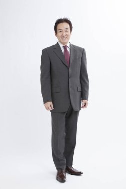 Beyaz arka planda poz veren takım elbiseli iş adamı 