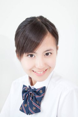 Okul üniformalı genç Japon kızın stüdyo portresi.