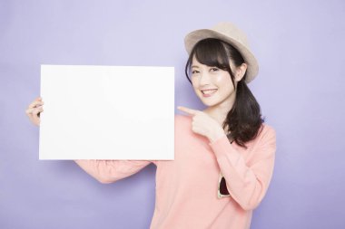 Boş beyaz pankartıyla gülümseyen Asyalı genç kadın.