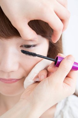 Güzellik salonunda makyaj yapan Asyalı güzel bir kadının yakın çekimi. 