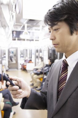 Yetişkin Japon iş adamının portresi metroda çalışacak.