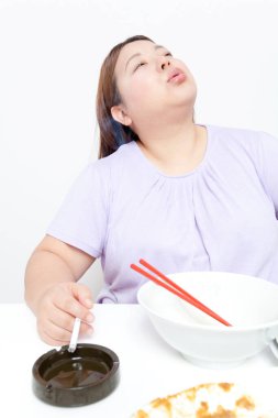 Kadın yemekten sonra sigara içiyor. 