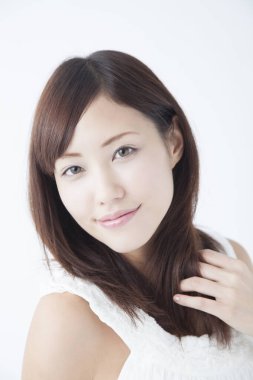 Genç, güzel Asyalı bir kadın izole edilmiş arka planda poz veriyor.  