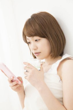 Evde cep telefonu kullanan güzel bir Japon kadın.