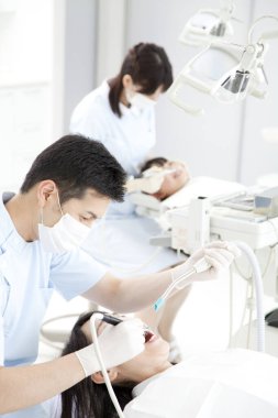 Klinikte çalışan kadın ve erkek dişçiler 