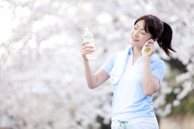 Kapatın güzel, olgun Asyalı kadın su içiyor.