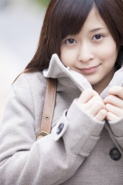 Genç ve güzel Asyalı bir kadının açık hava portresini kapat.