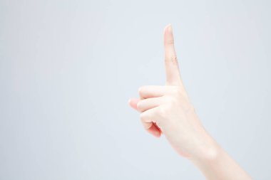 Beyaz arka planda el hareketi yapan kadınların yakın çekimi. 