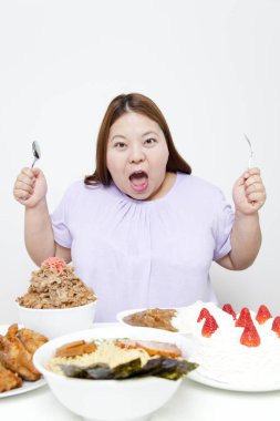 Asyalı kadın sağlıksız yiyecekler yiyor 