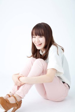 Yerde oturan Asyalı genç kadın.