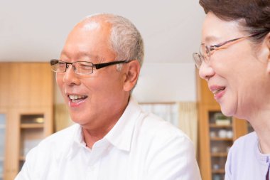 İçeride gözlüklü, gülümseyen yaşlı bir çift.