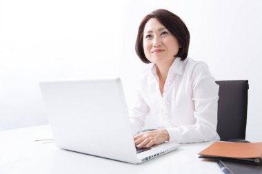 Masada dizüstü bilgisayar kullanan Asyalı iş kadını