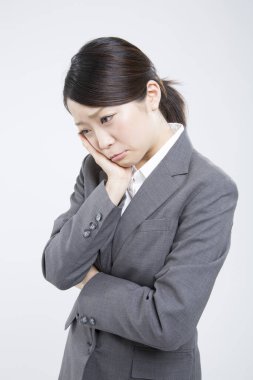 Başı ağrıyan iş kadını ofiste duruyor. 