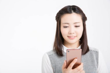 Beyaz arka planda akıllı telefon kullanan genç Asyalı kadın. 