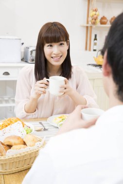 Çift mutfakta kahvaltı yapıyor.