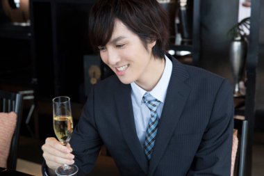 Bir bardak şampanyası olan genç bir iş adamı. 