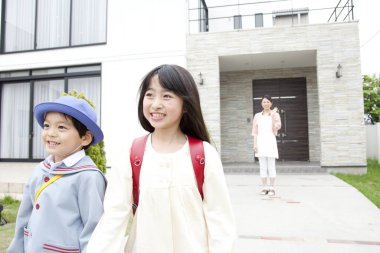 Modern evin dışında yürüyen gülümseyen çocuklar