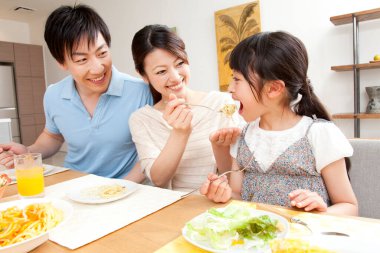 Genç bir aile yemek yiyor.