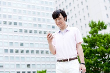 Genç ve yakışıklı adam akıllı telefon kullanıyor.