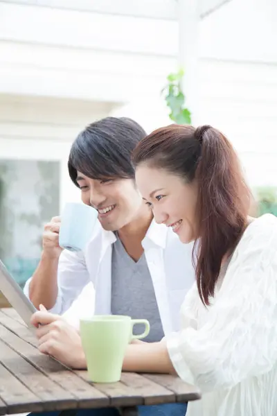Kafede Tablet Bilgisayar Kullanan Mutlu Asyalı Çift — Stok fotoğraf