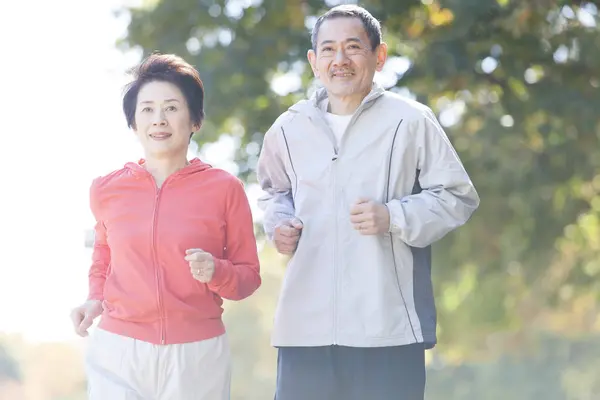 asian senior couple jogging in park