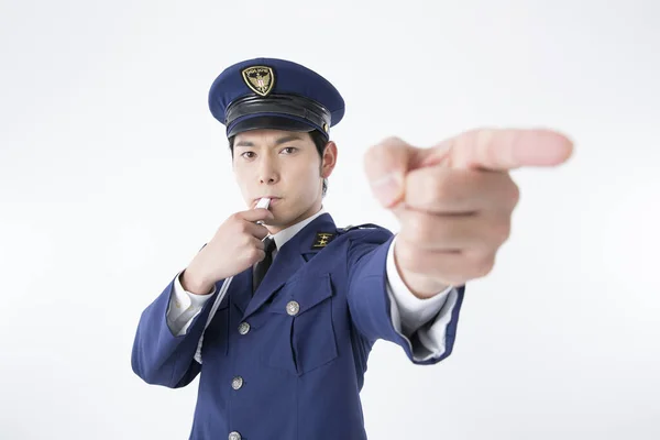 asian man wearing police uniform pointing at you with finger, isolated on white background.